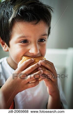 Boy eating a hamburger View Large Photo Image Stock Photo - Boy eating a hamburger. Fotosearch