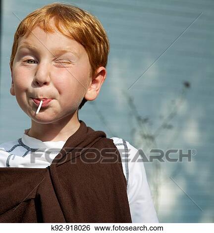 Boy eating a lollipop View Large Photo Image Stock Photograph - Boy eating a lollipop. Fotosearch