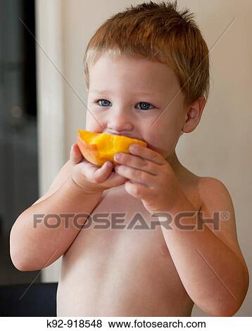 Boy eating a peach View Large Photo Image Stock Photo - Boy eating a peach. Fotosearch