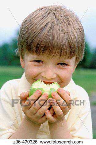 Boy eating apple View Large Photo Image Stock Photograph - Boy eating apple. Fotosearch