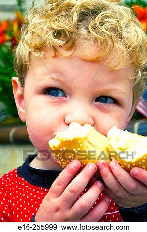 Boy eating bagel View Large Photo Image Stock Photo - Boy eating bagel. Fotosearch
