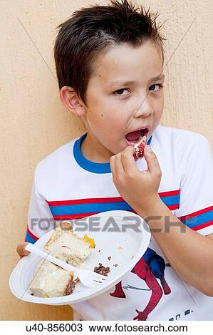 Stock Image - Boy eating Birthday cake. Fotosearch