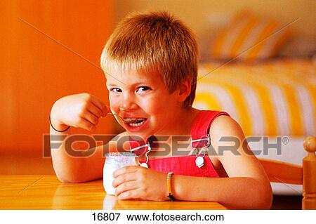 Boy eating yoghurt View Large Photo Image Stock Photo - Boy eating yoghurt. Fotosearch