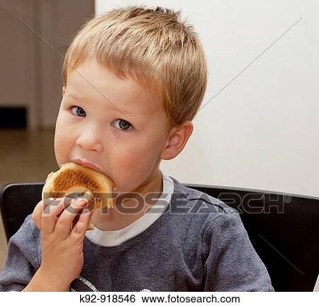 Boy eatinng a bagel View Large Photo Image Stock Photograph - Boy eatinng a bagel. Fotosearch