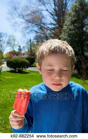 Boy enjoying a popsicle or ice pop. View Large Photo Image Picture - Boy enjoying a popsicle or ice pop.. Fotosearch