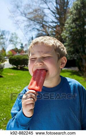 Boy enjoying a red ice pop or popsicle. View Large Photo Image Stock Photography - Boy enjoying a red ice pop or popsicle.. Fotosearch