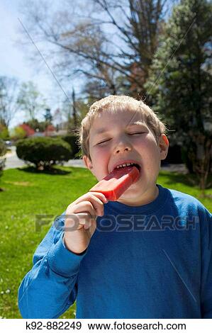Boy enjoying a red popsicle or ice pop. View Large Photo Image Stock Photo - Boy enjoying a red popsicle or ice pop.. Fotosearch