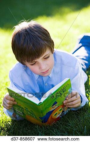 Boy enjoying reading a book in the garden View Large Photo Image Stock Photo - Boy enjoying reading a book in the garden. Fotosearch