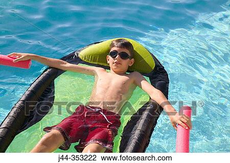 Boy floating on air matress in the pool View Large Photo Image Stock Image - Boy floating on air matress in the pool. Fotosearch
