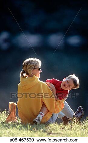 Boy giggles at being tickled by mother View Large Photo Image Stock Image - Boy giggles at being tickled by mother. Fotosearch