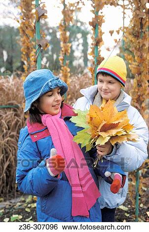 Boy gives leaves to girl View Large Photo Image Stock Photograph - Boy gives leaves to girl. Fotosearch