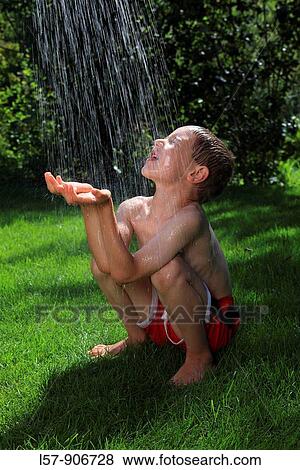 Stock Photo - boy having shower outdoors, Switzerland. Fotosearch