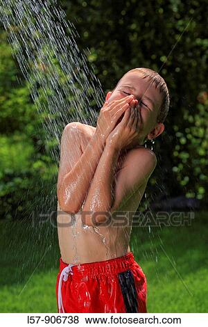 Stock Photo - boy having shower outdoors, Switzerland. Fotosearch