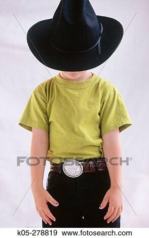 Boy hidden behind large black cowboy hat and wearing belt with silver buckle View Large Photo Image Stock Photo - Boy hidden behind large black cowboy hat and wearing belt with silver buckle. Fotosearch