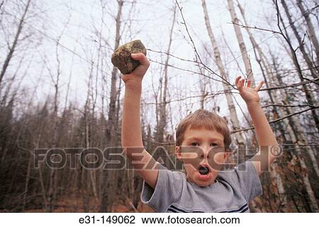 Boy holding a rock View Large Photo Image Stock Image - Boy holding a rock. Fotosearch