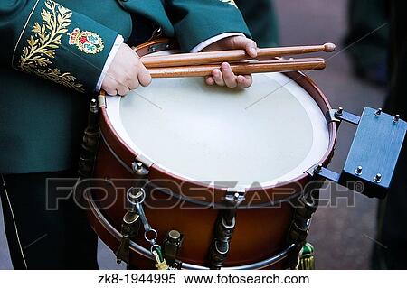 Stock Photography - Boy holding drumsticks on a drum during procession during Holy week, Spain.. Fotosearch