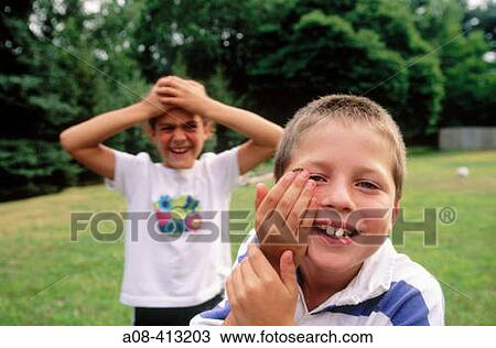 Stock Image - Boy holds live bumble bee on his fingertip as girl watches in disbelief. USA.. Fotosearch