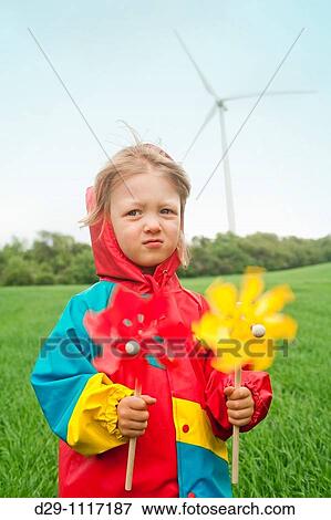 boy in colorful raincoat holding pinwheel standing in front of wind turbine View Large Photo Image Stock Photo - boy in colorful raincoat holding pinwheel standing in front of wind turbine. Fotosearch
