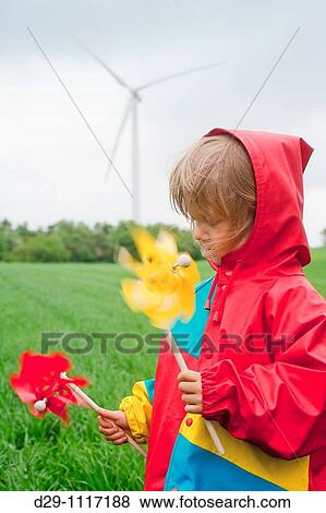 boy in colorful raincoat holding pinwheel standing in front of wind turbine View Large Photo Image Stock Photo - boy in colorful raincoat holding pinwheel standing in front of wind turbine. Fotosearch