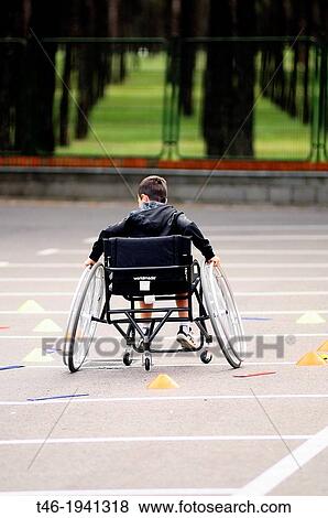 Stock Photo - Boy in wheelchair, circuit practice. Fotosearch