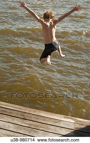 Boy jumping from boat dock into the Albemarle Sound View Large Photo Image Picture - Boy jumping from boat dock into the Albemarle Sound. Fotosearch