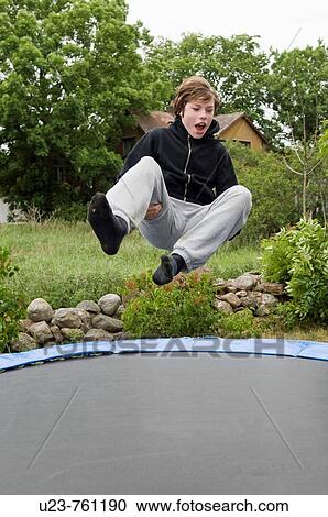 Stock Image - Boy jumping high on a trampolin.. Fotosearch