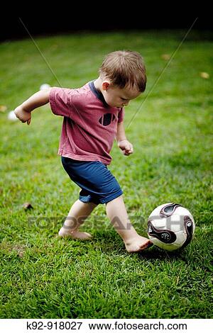 Boy kicking a soccer ball View Large Photo Image Stock Photo - Boy kicking a soccer ball. Fotosearch