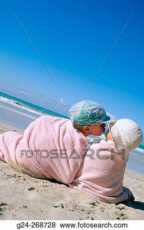 Boy kissing sister wrapped in towels on beach View Large Photo Image Stock Photo - Boy kissing sister wrapped in towels on beach. Fotosearch