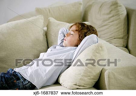 Stock Photo - Boy laying on coach. Fotosearch