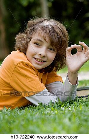 Boy laying on grass View Large Photo Image Stock Image - Boy laying on grass. Fotosearch