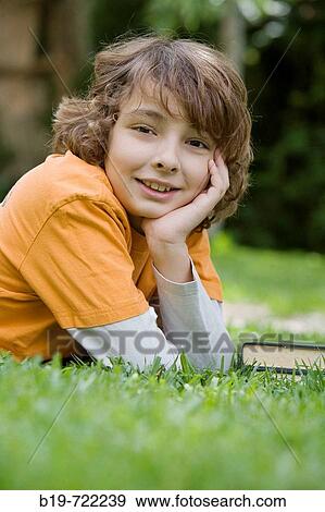 Stock Photo - Boy laying on grass. Fotosearch