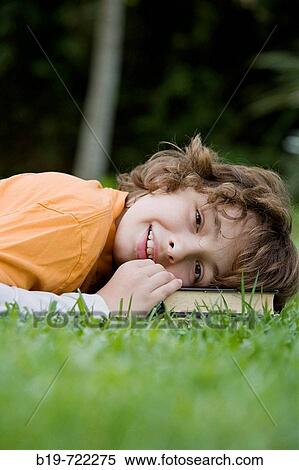 Stock Photography - Boy laying on grass. Fotosearch