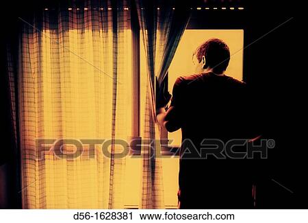 Stock Image - Boy looking through a window, Benidorm, Alicante province, Spain. Fotosearch