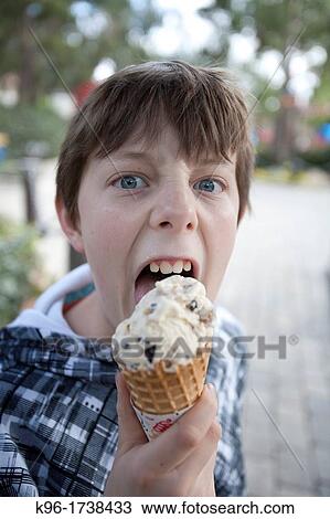 boy looking unhappy eating an ice cream cone View Large Photo Image Stock Image - boy looking unhappy eating an ice cream cone. Fotosearch