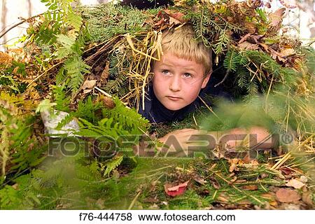 Boy lost in woods taking refuge in? debris shelter? to protect himself from hypothermia, a technique that can save one's life View Large Photo Image Stock Photo - Boy lost in woods taking refuge in? debris shelter? to protect himself from hypothermia, a technique that can save one's life. Fotosearch