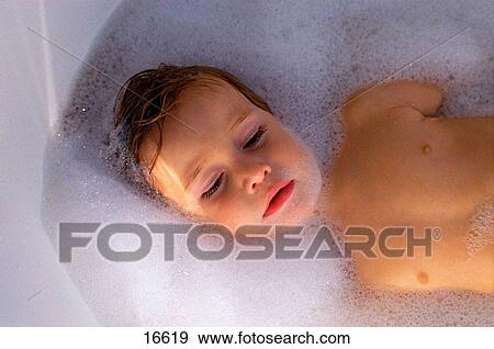 Stock Photo - Boy lying in bubble bath. Fotosearch