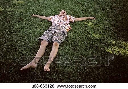 Stock Photo - Boy lying on grass. Fotosearch