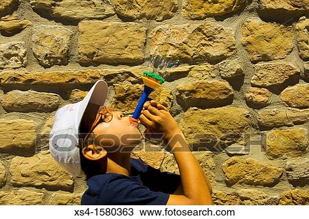 Stock Image - Boy make soap bubbles. Fotosearch