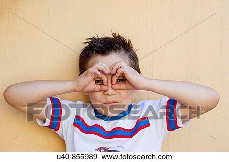 Stock Photo - Boy making glasses with hands. Fotosearch