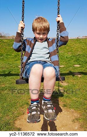 Boy of 6 on a swing in the Uk View Large Photo Image Stock Image - Boy of 6 on a swing in the Uk. Fotosearch