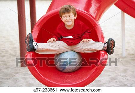 Boy on red sliding board View Large Photo Image Stock Image - Boy on red sliding board. Fotosearch