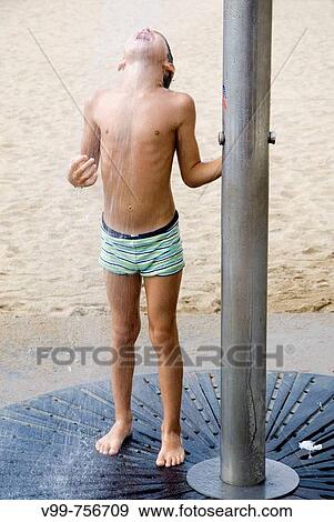 Stock Photo - Boy on the beach, taking a shower. Fotosearch