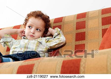Boy on the sofa looking away. View Large Photo Image Stock Photo - Boy on the sofa looking away.. Fotosearch