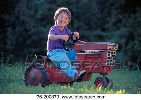 Boy on toy tractor View Large Photo Image Stock Photo - Boy on toy tractor. Fotosearch