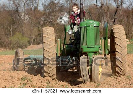 Boy on tractor View Large Photo Image Stock Image - Boy on tractor. Fotosearch