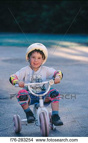 Boy on tricycle View Large Photo Image Picture - Boy on tricycle. Fotosearch