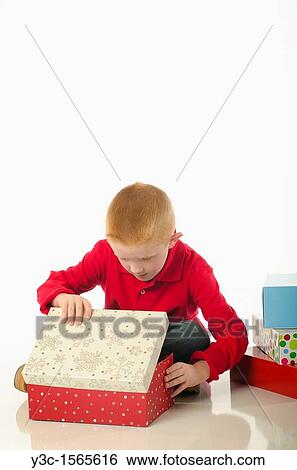 Stock Photograph - Boy opening a Christmas present. Fotosearch