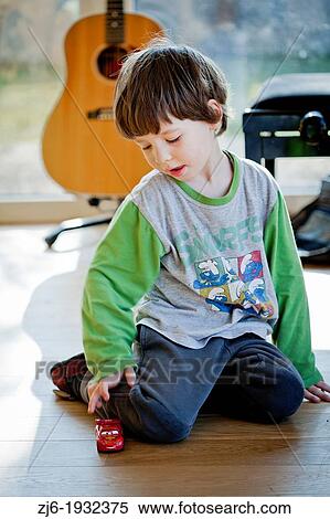 Boy playing alone indoor with a toy car. View Large Photo Image Stock Photography - Boy playing alone indoor with a toy car.. Fotosearch