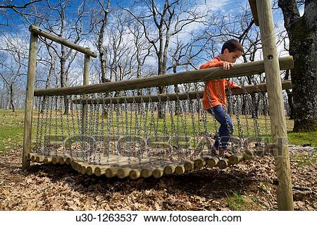 Boy playing in a children's playground, in a forest of Sierra de Lagunilla, next to Sierra de B? jar, in Salamanca province, Biosphere Reserve of Sierra de B? jar and Francia View Large Photo Image Stock Photo - Boy playing in a children's playground, in a forest of Sierra de Lagunilla, next to Sierra de B? jar, in Salamanca province, Biosphere Reserve of Sierra de B? jar and Francia. Fotosearch