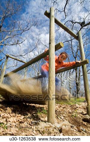 Boy playing in a children's playground, in a forest of Sierra de Lagunilla, next to Sierra de B? jar, in Salamanca province, Biosphere Reserve of Sierra de B? jar and Francia View Large Photo Image Stock Photo - Boy playing in a children's playground, in a forest of Sierra de Lagunilla, next to Sierra de B? jar, in Salamanca province, Biosphere Reserve of Sierra de B? jar and Francia. Fotosearch